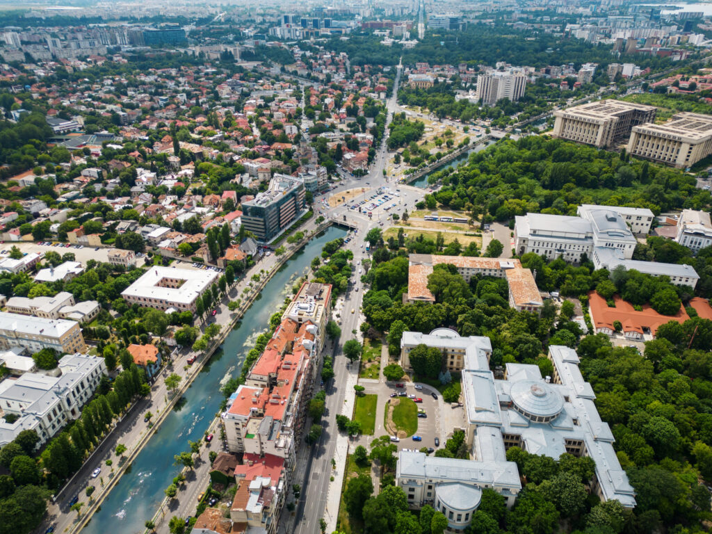 Aerial drone view of Bucharest, Romania. City downtown with water channel, greenery and multiple buildings