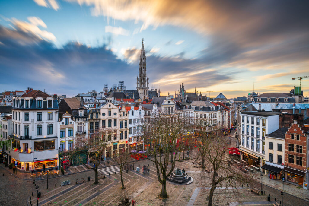Brussels, Belgium plaza and skyline with the Town Hall tower at dusk.