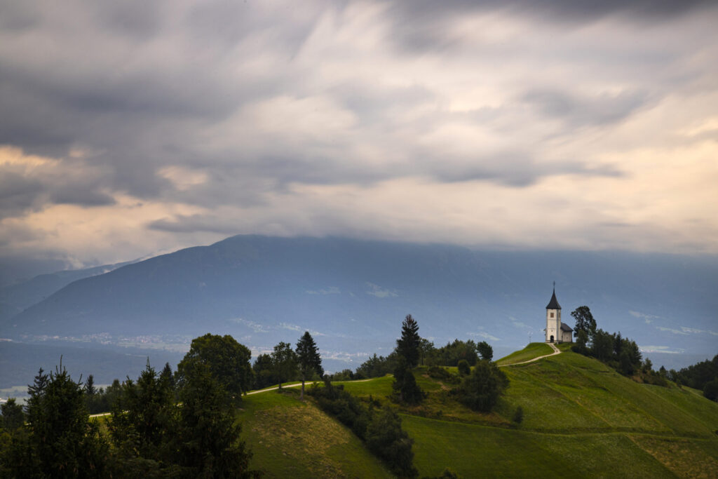 Jamnik, Slovenia. The Jamnik Church is a charming 15th-century chapel in the Kamnik-Savinja Alps near Kranj, breathtaking views of the surrounding mountainous landscape.
