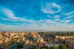 Rome Italy Summer Time Cityscape. Colosseum and the Roman Forum. Popular European Destination. Clear Sky with Some Clouds.
