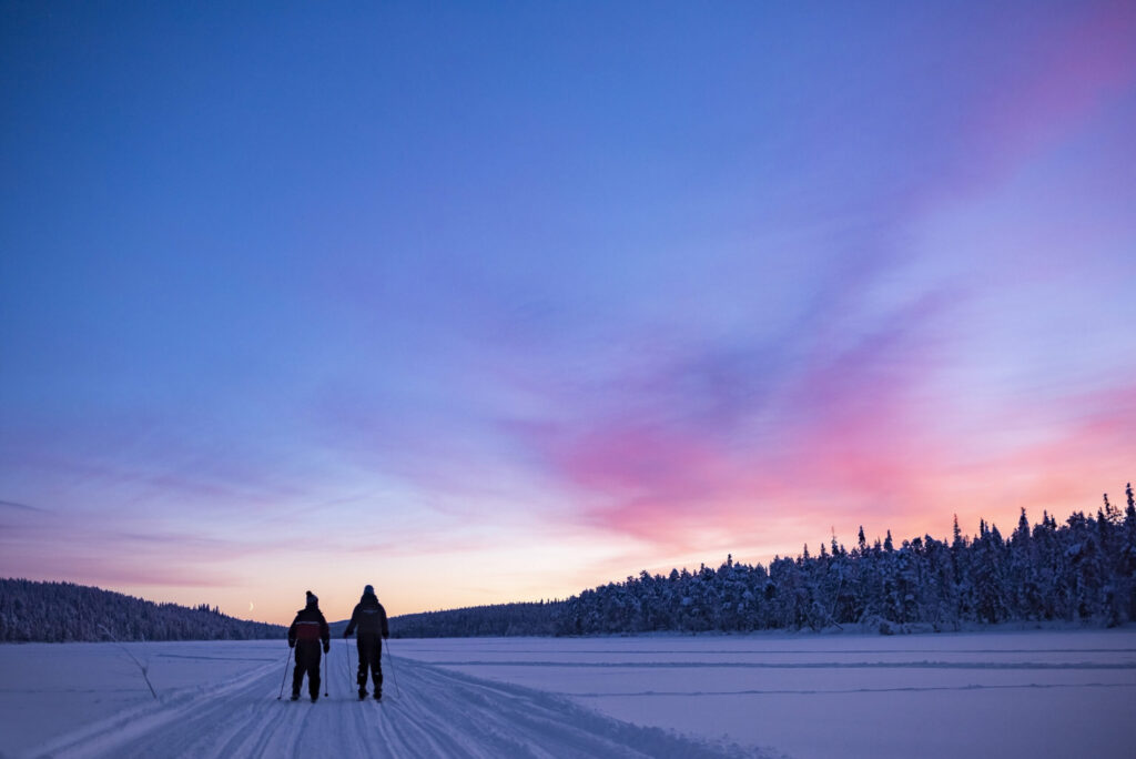 Skiing on the frozen lake at Torassieppi at sunset, Lapland, Finland