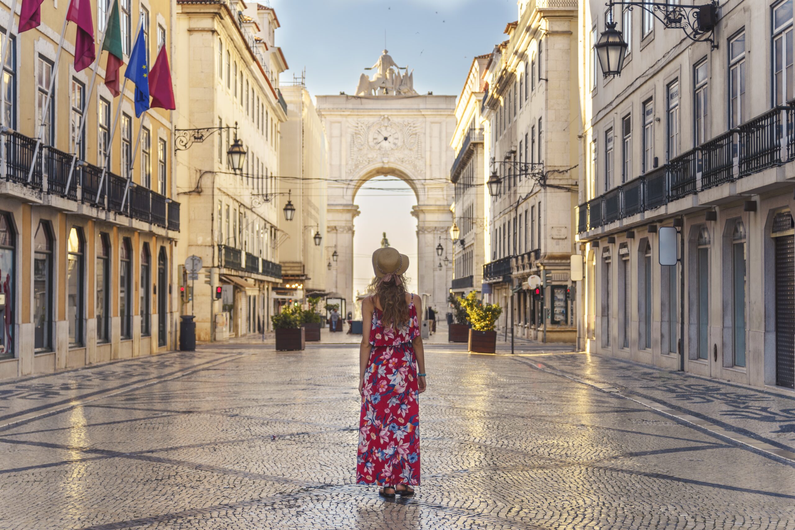 A young female in a floral dress walking around the Commerce Square in Lisbon, Portugal