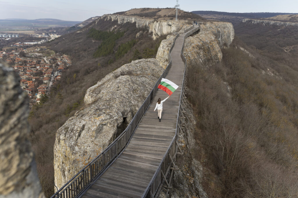 Young woman outdoors holding the Bulgarian flag – showing national pride in a natural setting