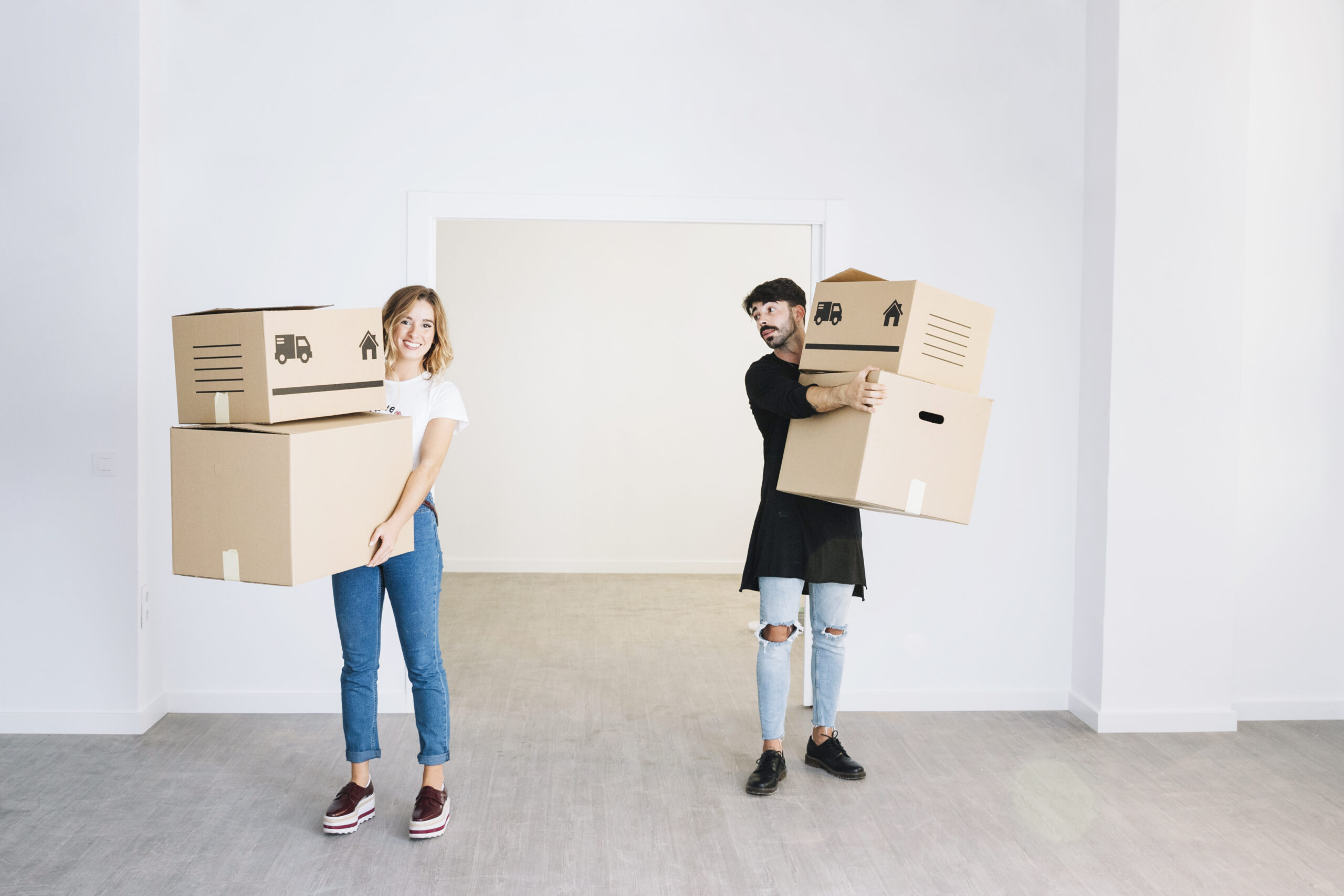 Couple holding moving boxes – preparing for a home relocation together
