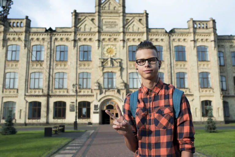 Medium shot of teenage boy showing peace sign – casual and friendly gesture