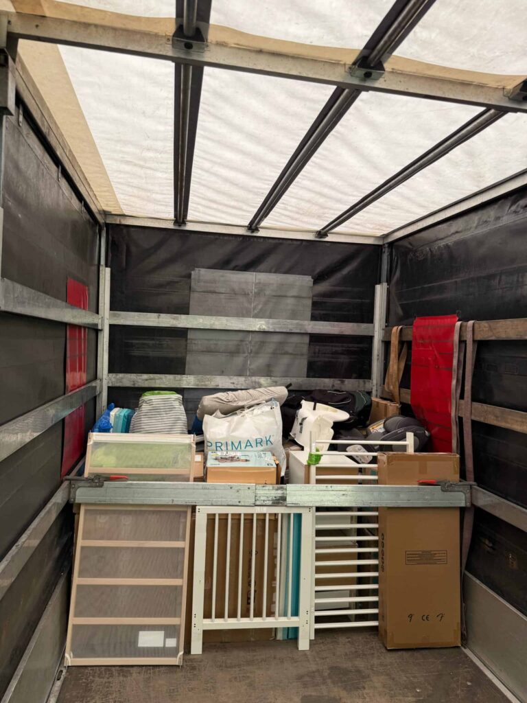 Interior of a moving van neatly filled with baby furniture parts, boxes, and household items, highlighting cheap removals to Holland.