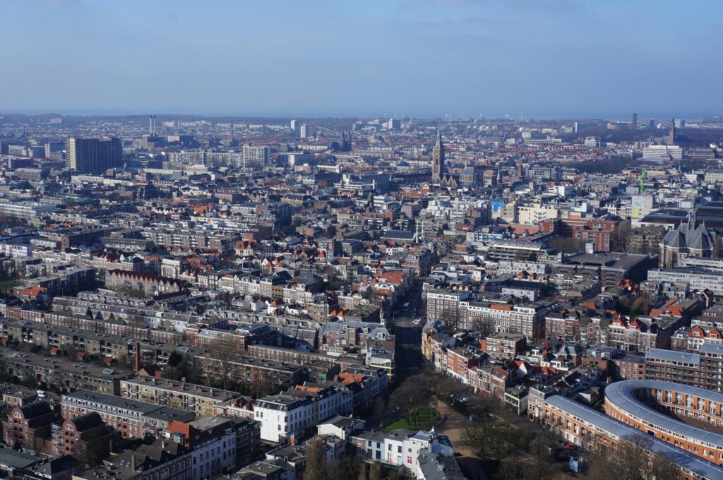 Aerial view of a densely built Dutch city showcasing organized urban planning and historic architecture, illustrating urban life in the Netherlands for the "living in Austria vs Netherlands" comparison.