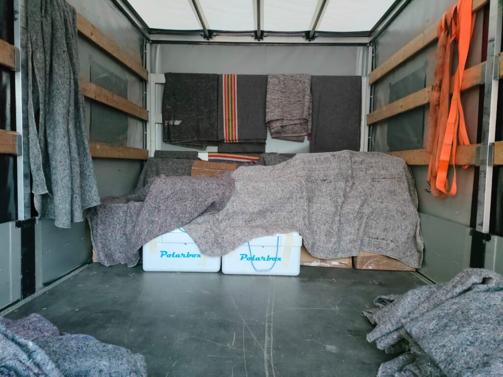 Interior of a moving van with blankets draped over furniture and Polarbix coolers, demonstrating careful handling by packers and movers Netherlands