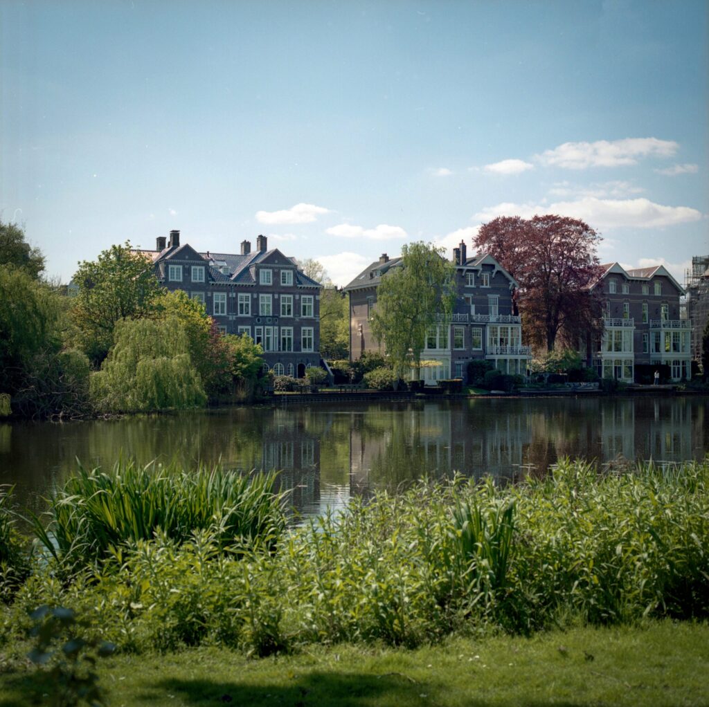 Canal-side view of historic Dutch houses reflected in the water, evoking the charm you’ll encounter after relocating to the Netherlands.