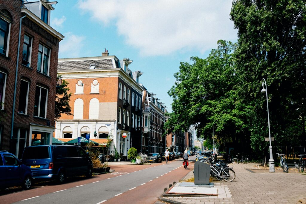 Street scene in a Dutch city with cyclists and traditional brick buildings, illustrating urban life when relocating to the Netherlands.