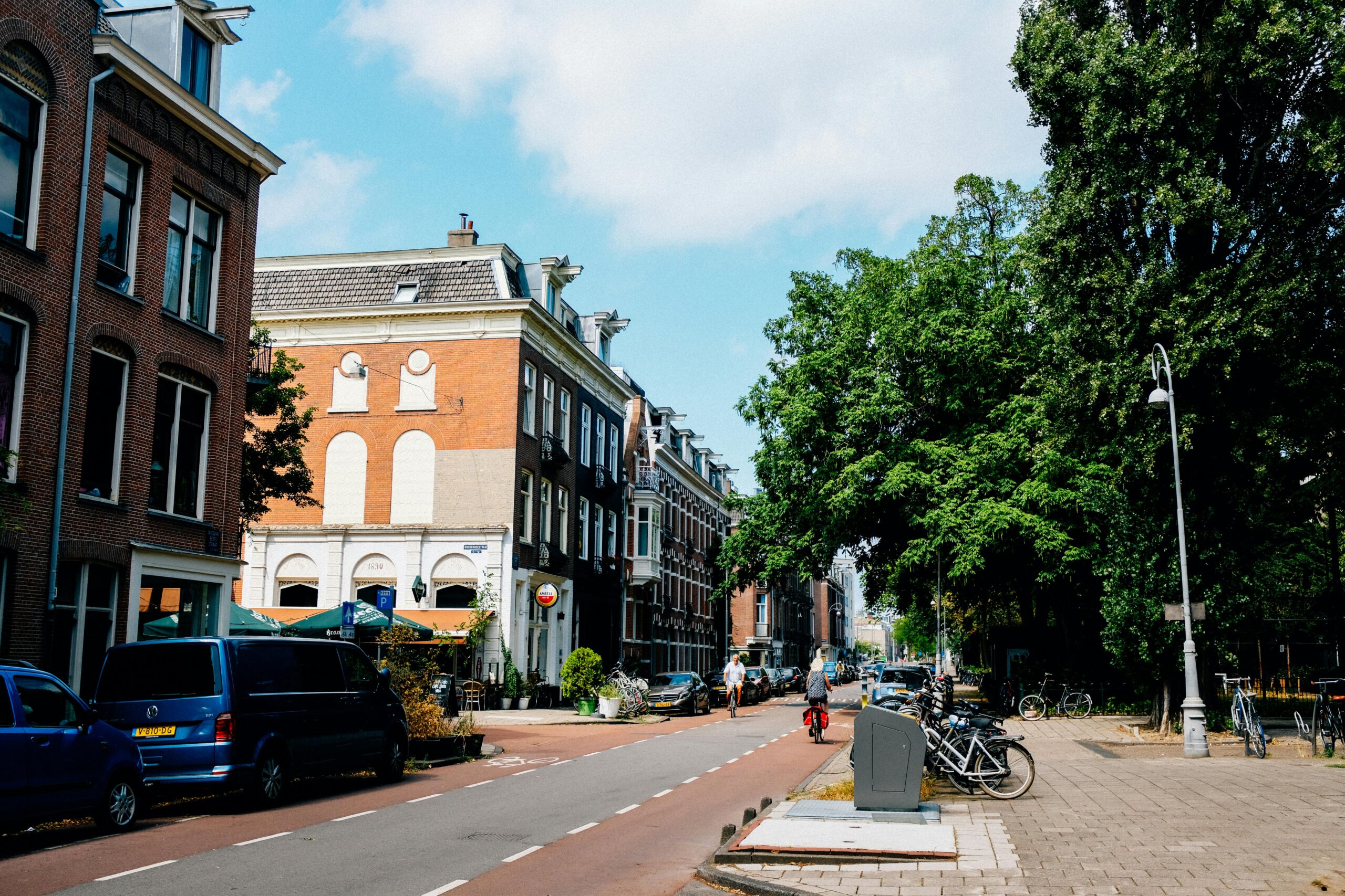 Street scene in a Dutch city with cyclists and traditional brick buildings, illustrating urban life when relocating to the Netherlands.