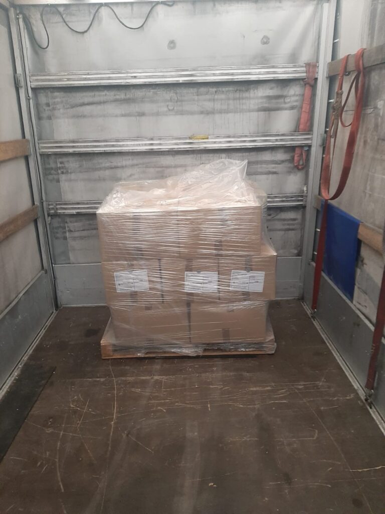 Interior of a small removal van loaded with wooden crates securely strapped for a small removals to Netherlands shipment.