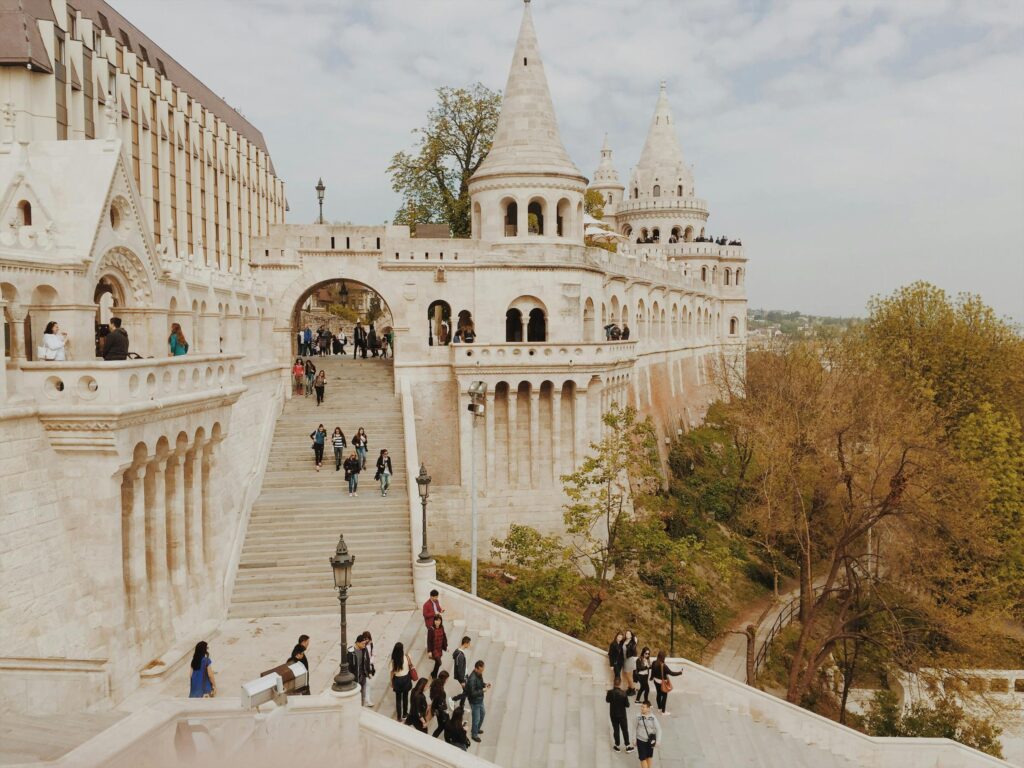 Visitors walking on the white stone terraces and stairways of Fisherman’s Bastion in Budapest, Hungary.