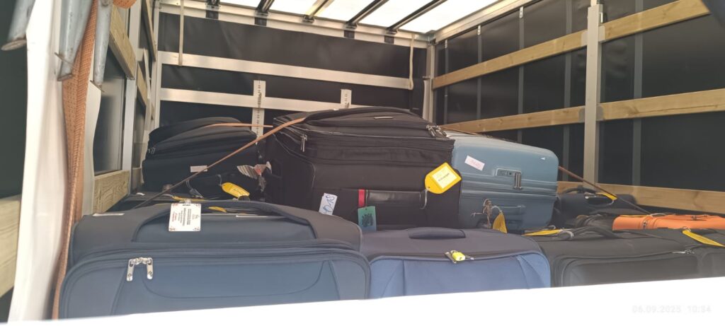 Neatly stacked suitcases inside a moving truck, showing professional luggage transport service for European relocations with VANonsite.