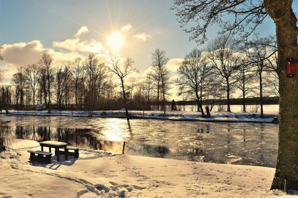 Snowy riverside park at sunset in Northern Europe, showing a peaceful winter landscape that reflects the destinations served by VANonsite European relocations and international removals.