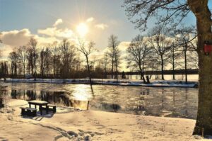 Snowy riverside park at sunset in Northern Europe, showing a peaceful winter landscape that reflects the destinations served by VANonsite European relocations and international removals.