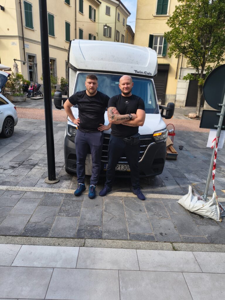 Two VANonsite movers standing in front of a removal van on a city street, ready for an international move