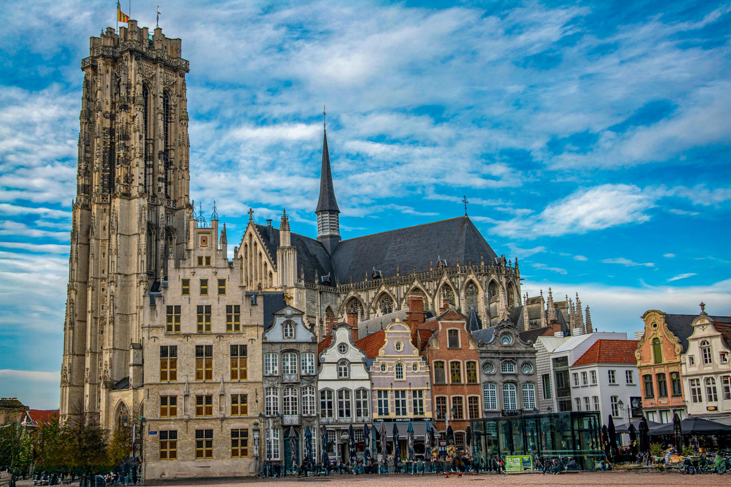Saint Rumbold's Cathedral and historic guild houses on the main square in Mechelen Belgium, shown as a destination for people moving to Belgium with VANonsite European removals