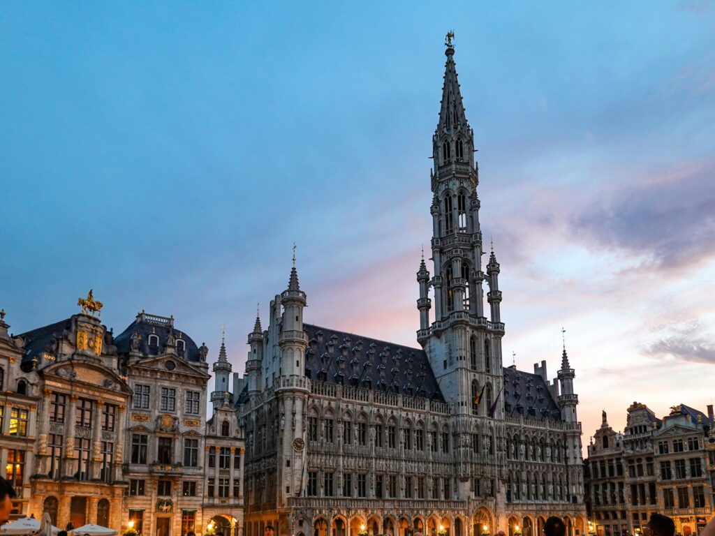 Brussels Town Hall and historic guild houses on the Grand Place at sunset, a destination for people moving to Belgium with VANonsite European removals
