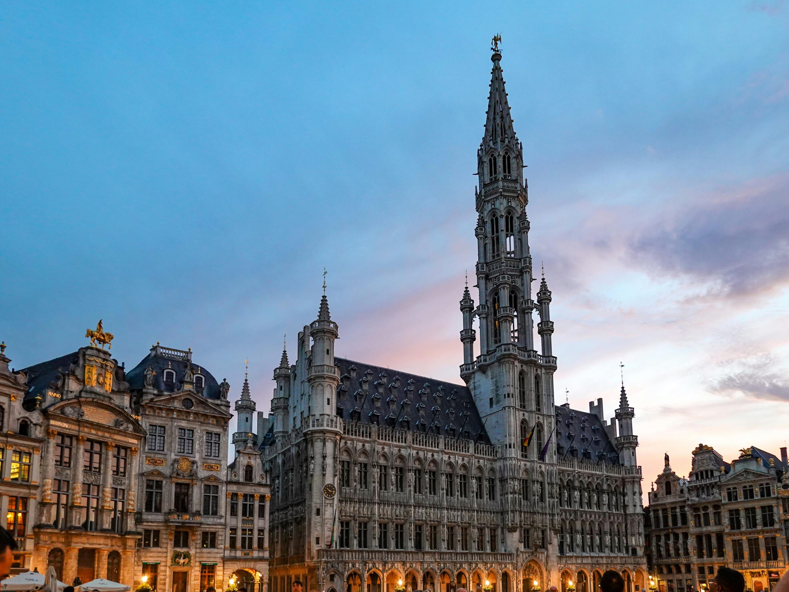 Brussels Town Hall and historic guild houses on the Grand Place at sunset, a destination for people moving to Belgium with VANonsite European removals
