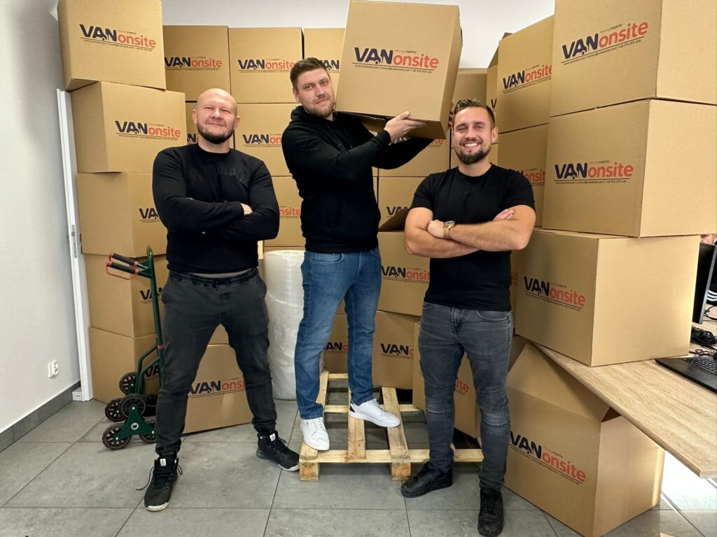 Young VANonsite moving team standing in front of branded boxes, ready to handle stress free European relocations and international moving services