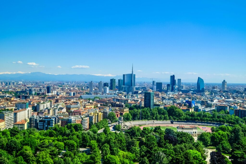 Panoramic view of Milan skyline with Porta Nuova skyscrapers rising above parks and historic buildings, representing life after moving to Italy with VANonsite European removals