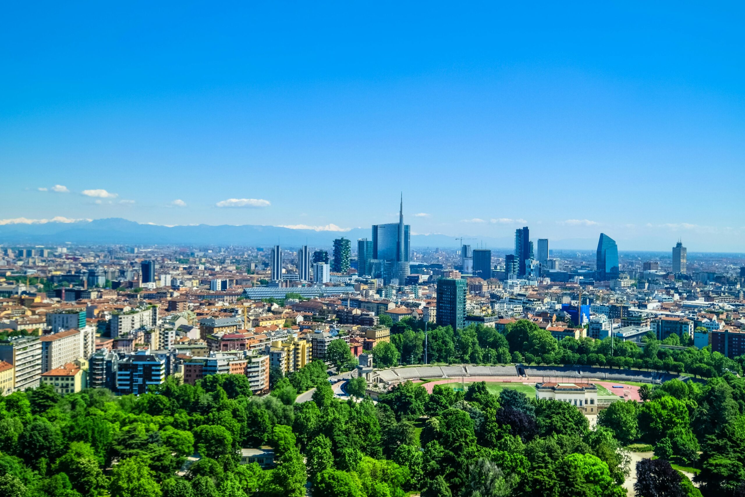 Panoramic view of Milan skyline with Porta Nuova skyscrapers rising above parks and historic buildings, representing life after moving to Italy with VANonsite European removals
