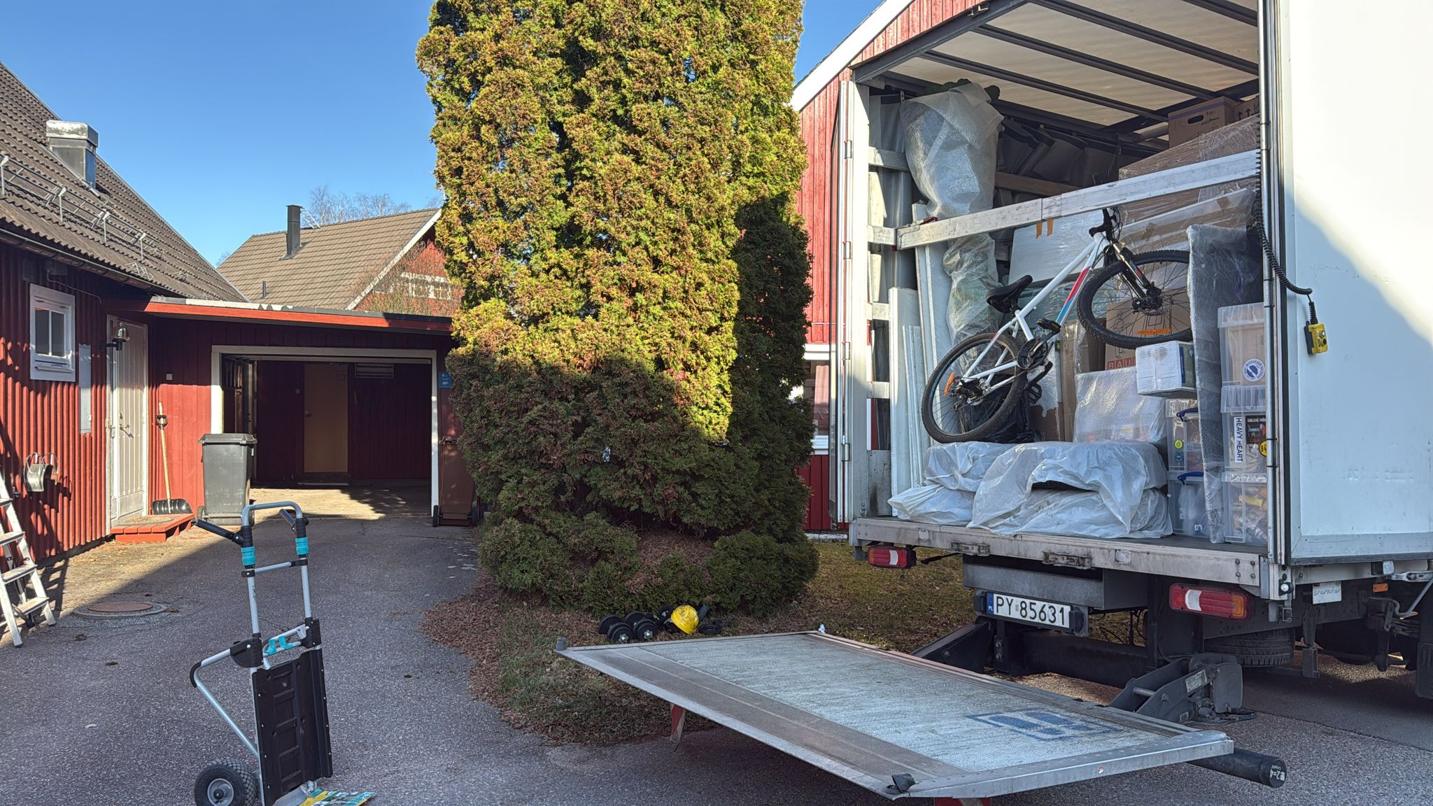 Removal truck with a lowered tail-lift, wrapped furniture and a bicycle