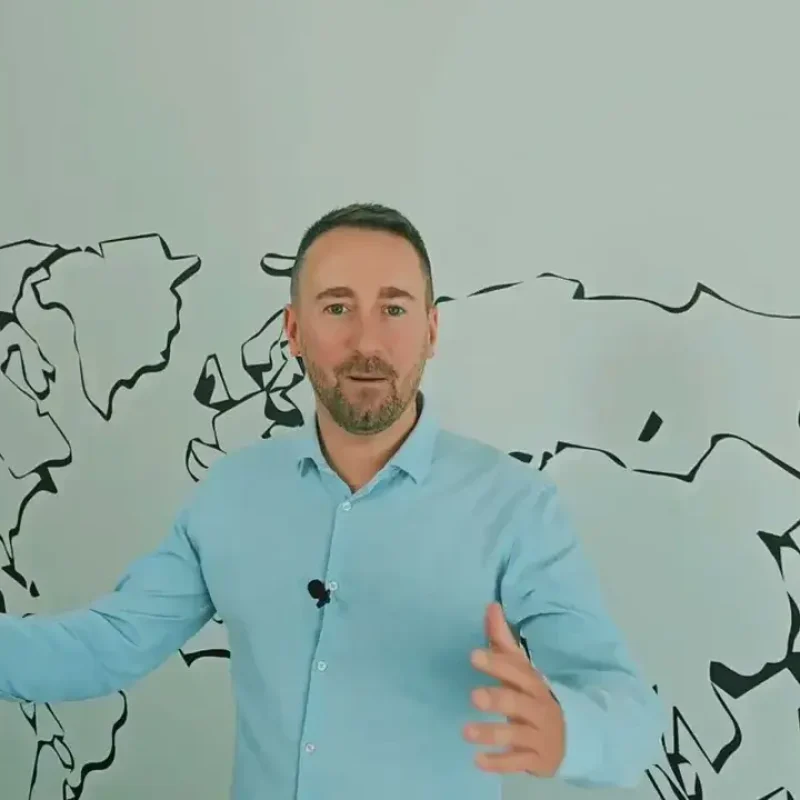 VANonsite moving specialist standing in front of a world map, inviting clients to plan stress free European relocations and international moves